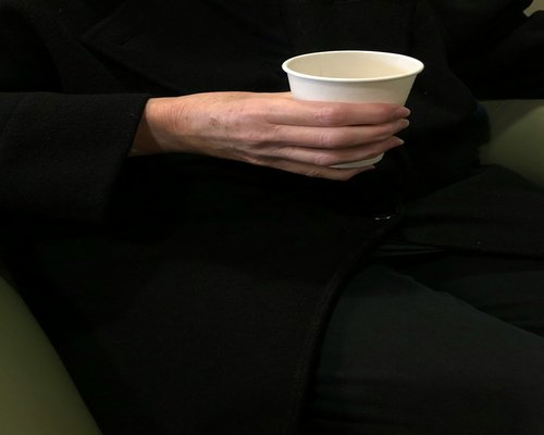 Close up of a person holding a cup of tea relaxing